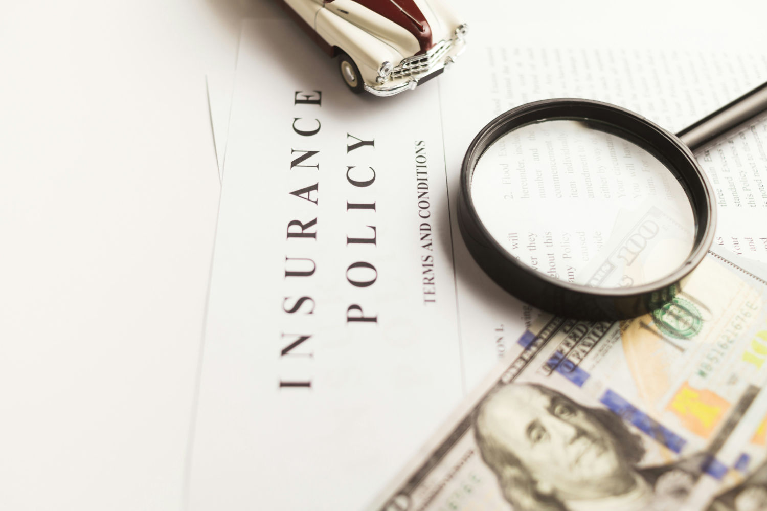 A photo of the top of an insurance policy with a magnifying glass